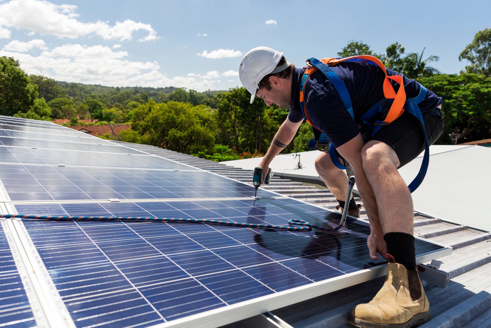 Solar Panel Technician with Drill Installing Solar Panels